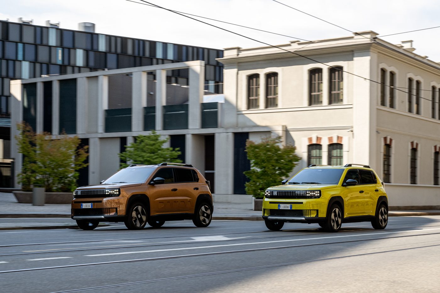 Два автомобила FIAT Grande Panda на градска улица с трамвайни релси